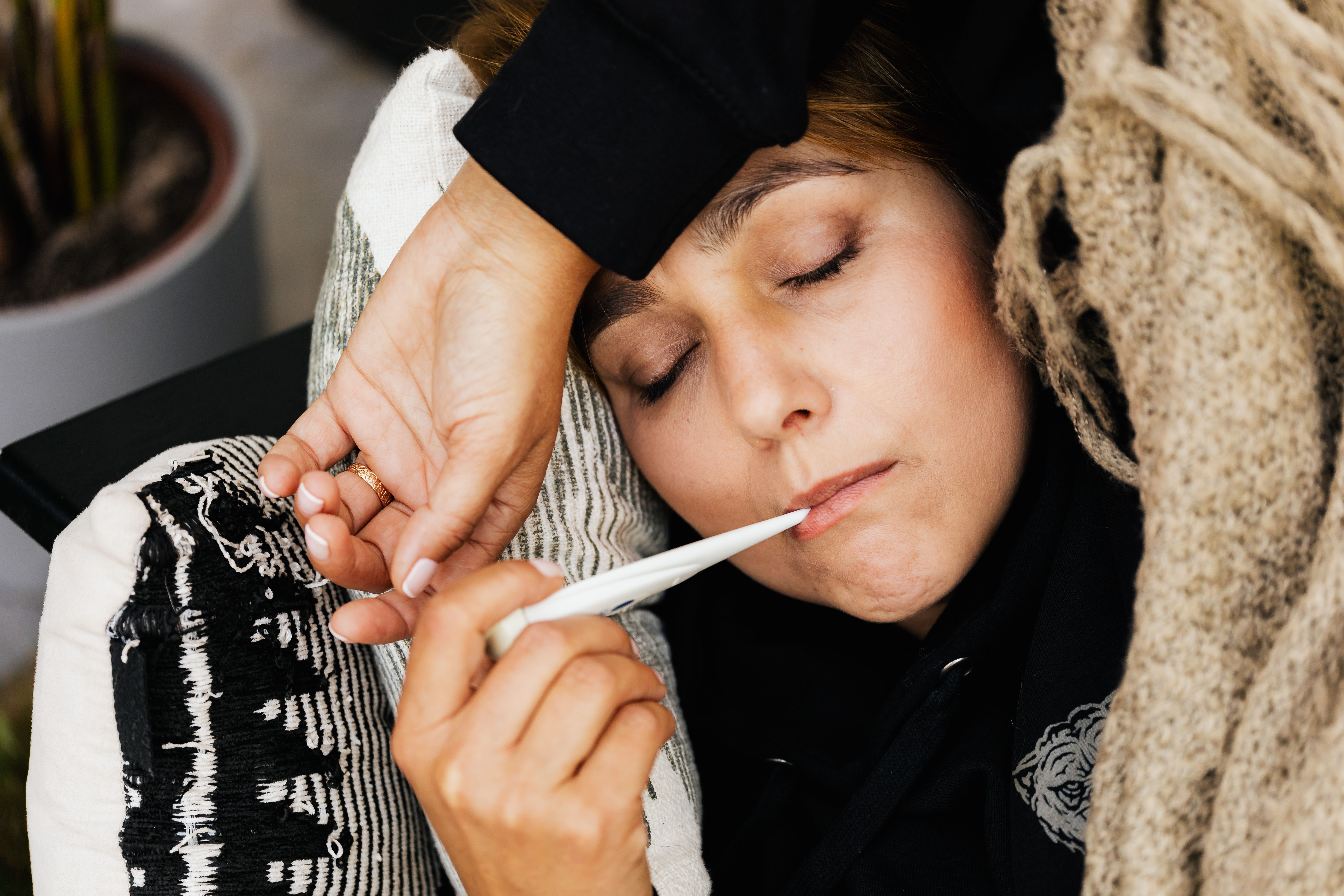 Persona con síntomas de gripe consultando medicamentos seguros con un farmacéutico